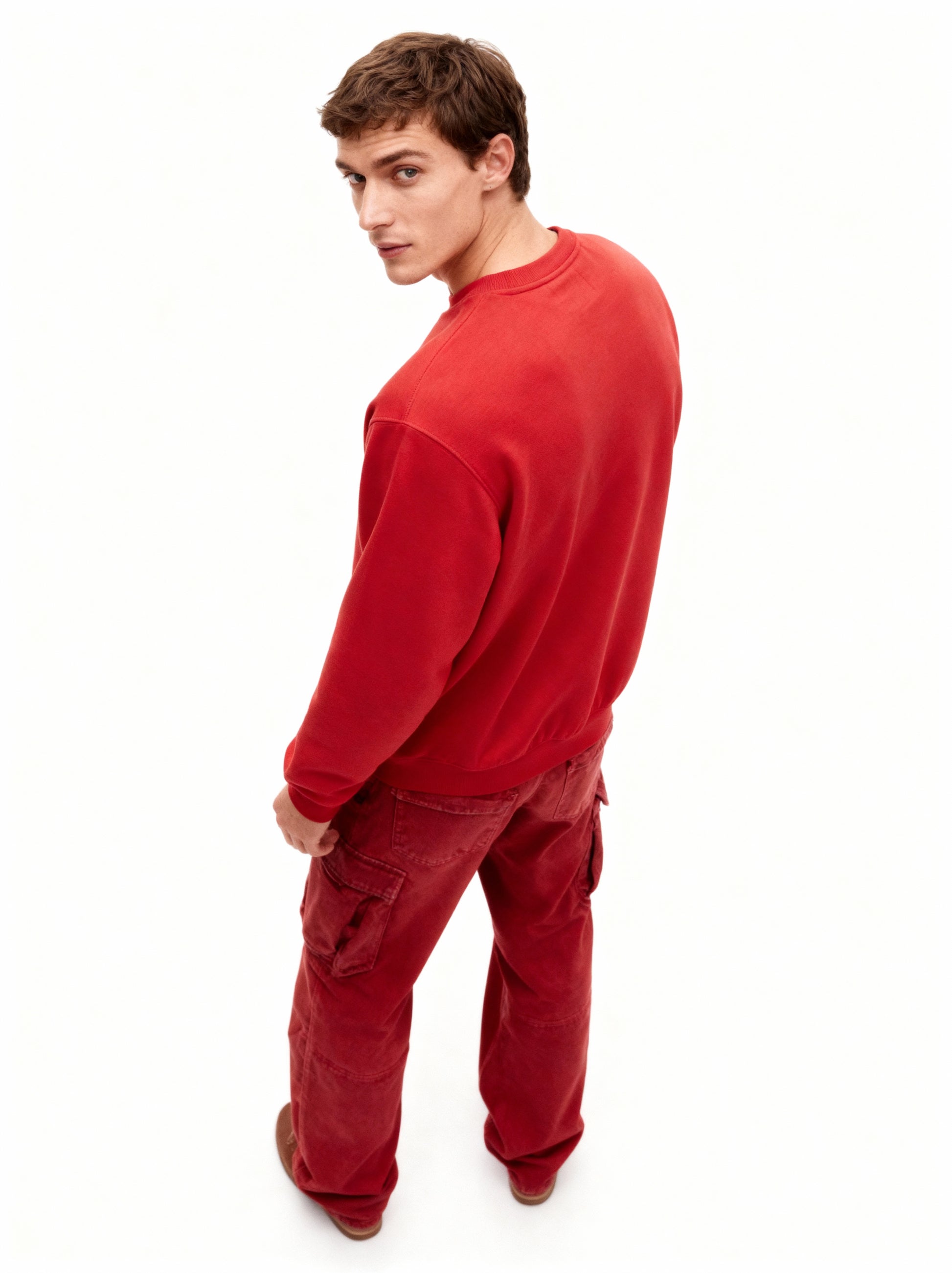 Man wearing a red sweatshirt and pants on a white background