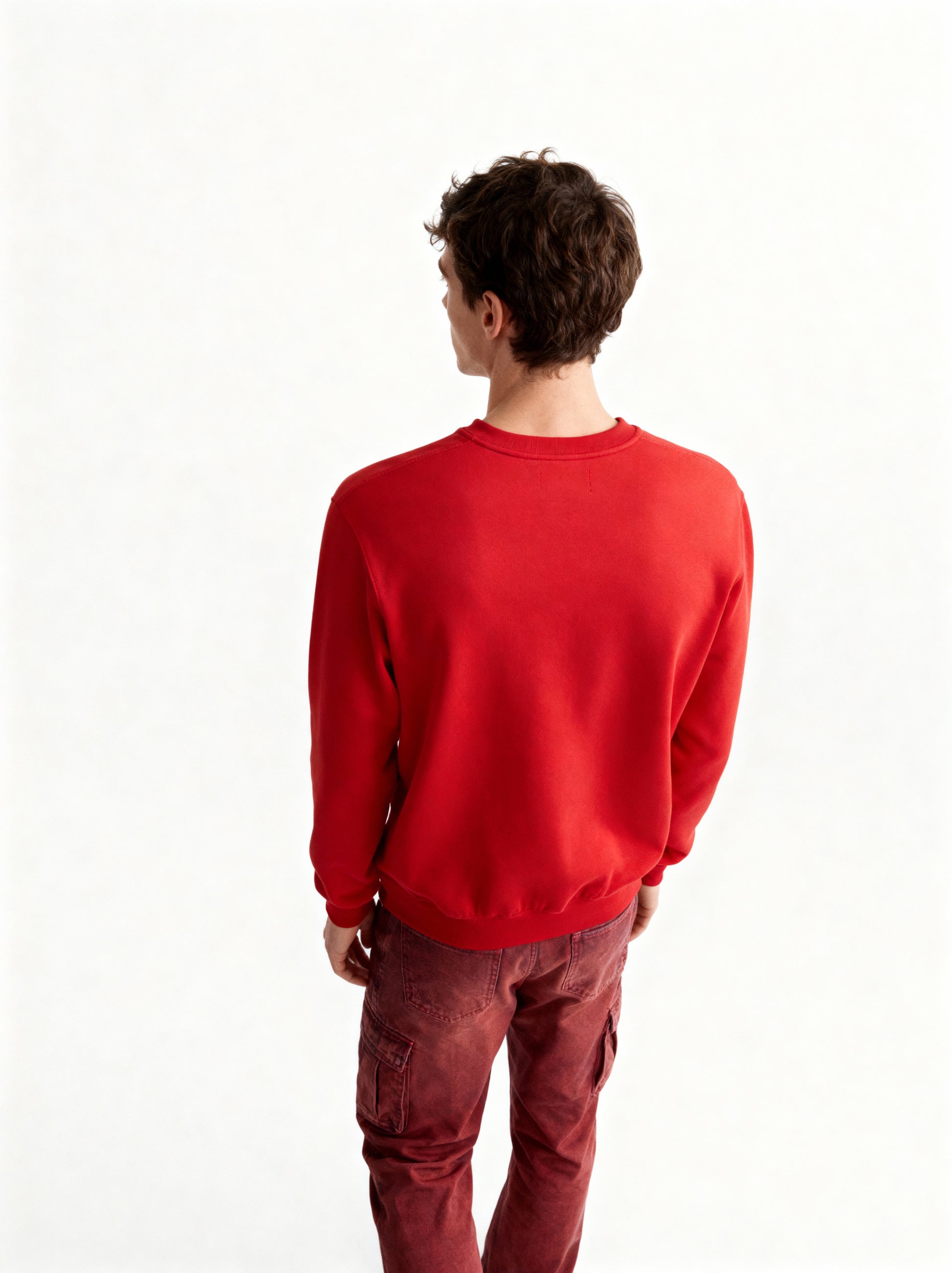 Person wearing a red sweatshirt and red pants on a white background