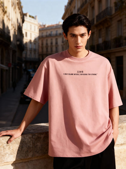 Man wearing a pink t-shirt with text in an urban setting