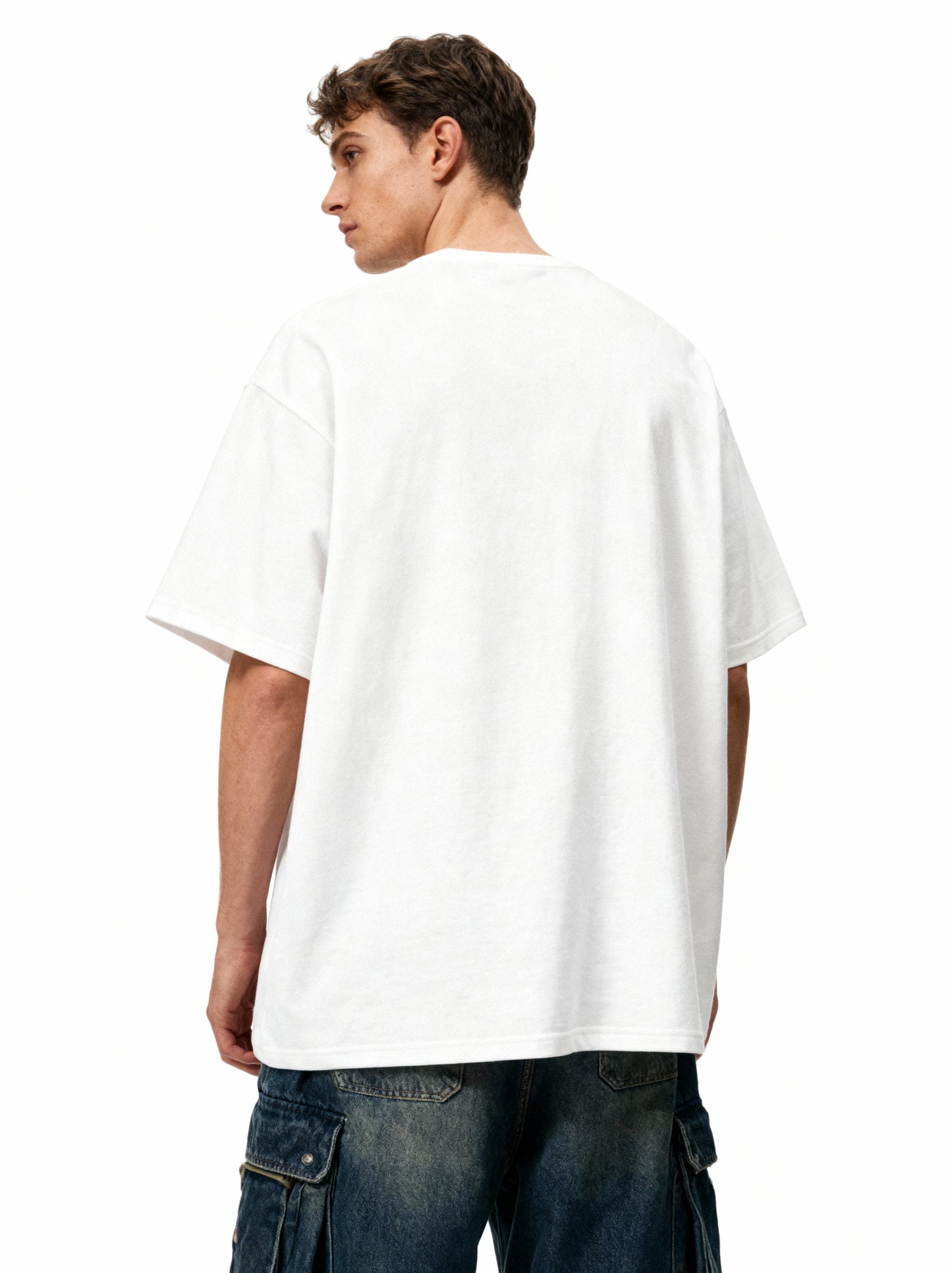 Person wearing a plain white t-shirt on a white background