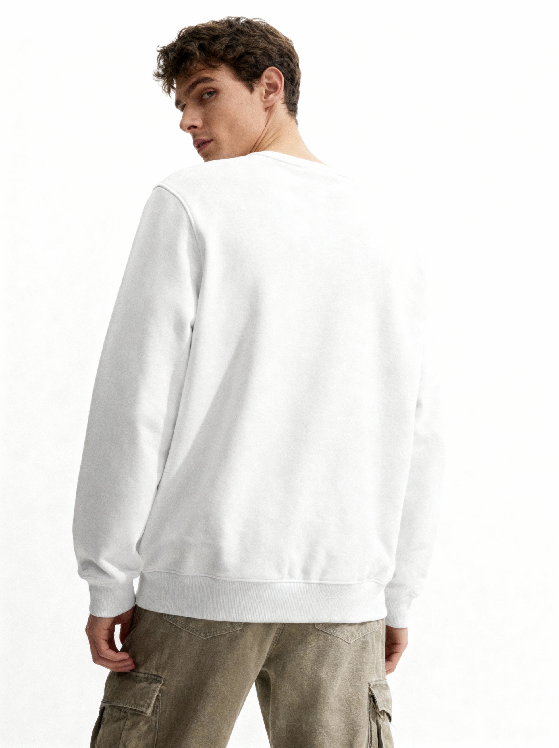 Person wearing a plain white sweatshirt on a white background