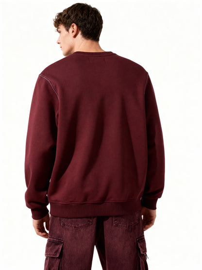 Person wearing a maroon sweatshirt and cargo pants on a white background