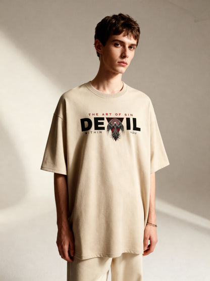 Person wearing a beige t-shirt with graphic design and text on a plain background