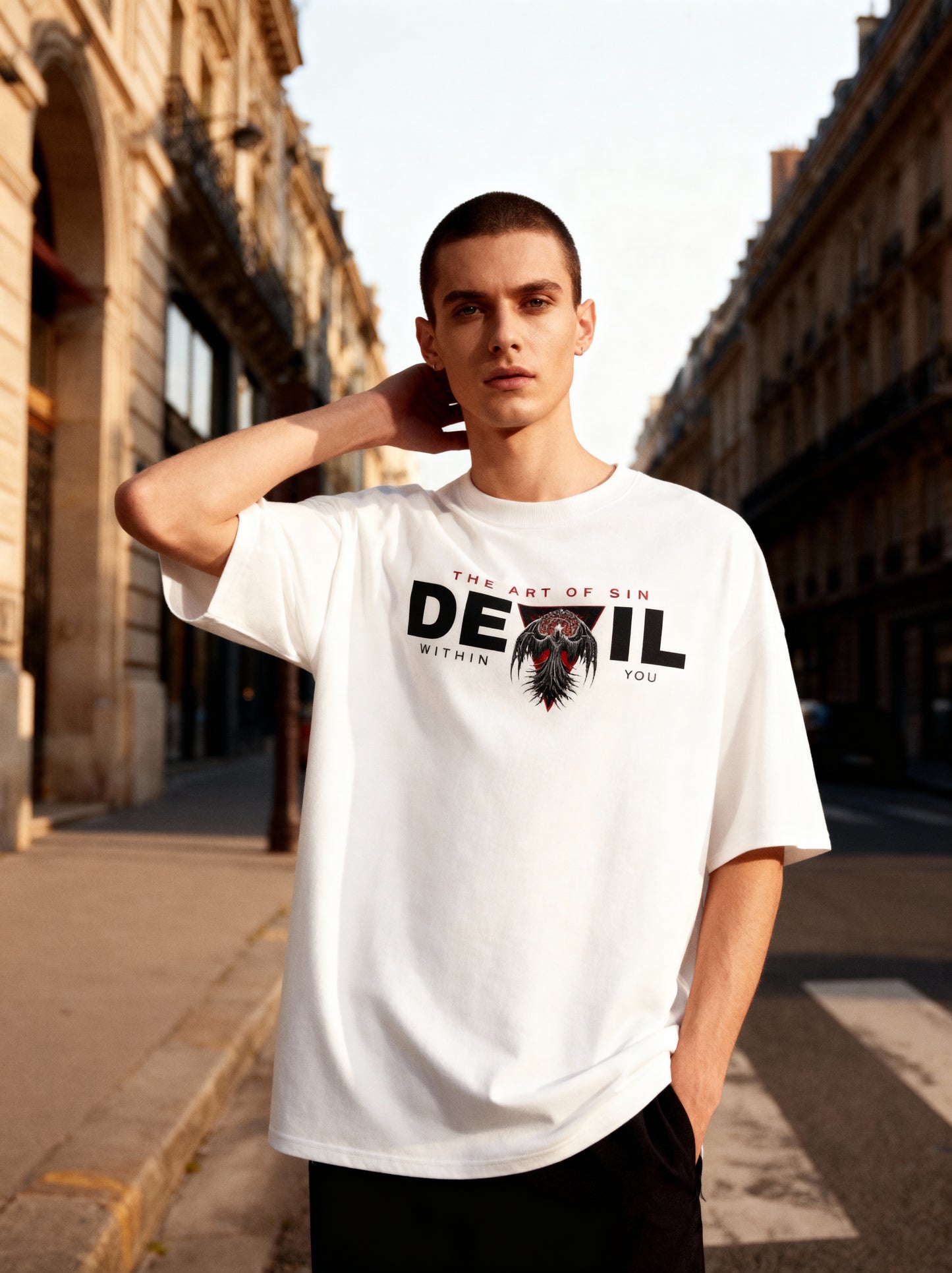 Man wearing a white t-shirt with a graphic design on a city street