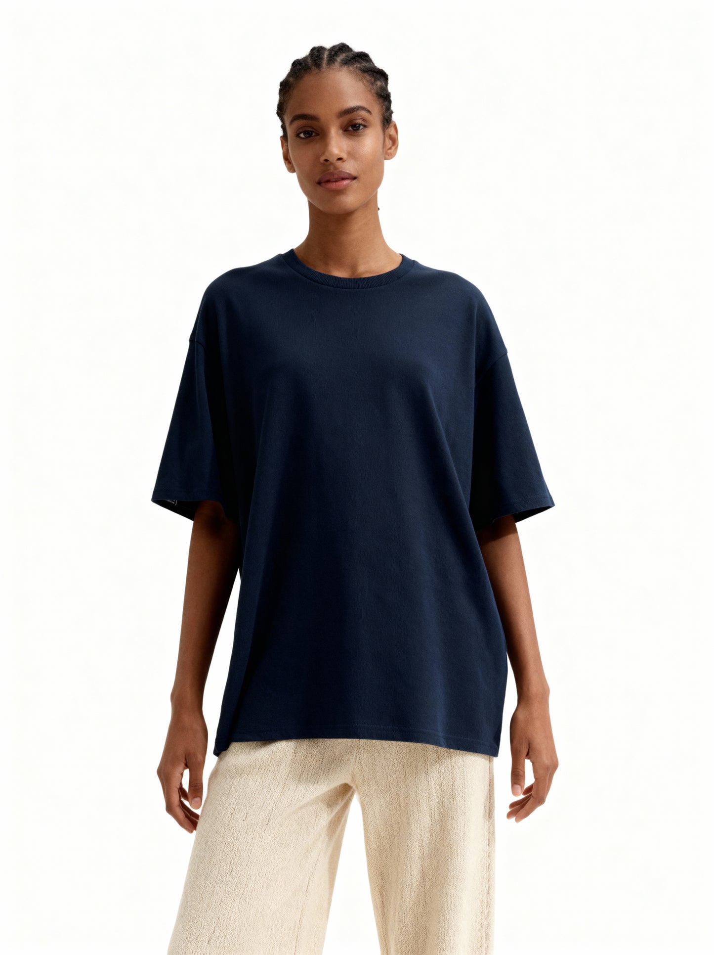 Woman wearing a navy blue t-shirt and beige pants on a white background