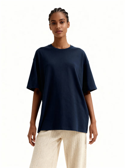 Woman wearing a navy blue t-shirt and beige pants on a white background